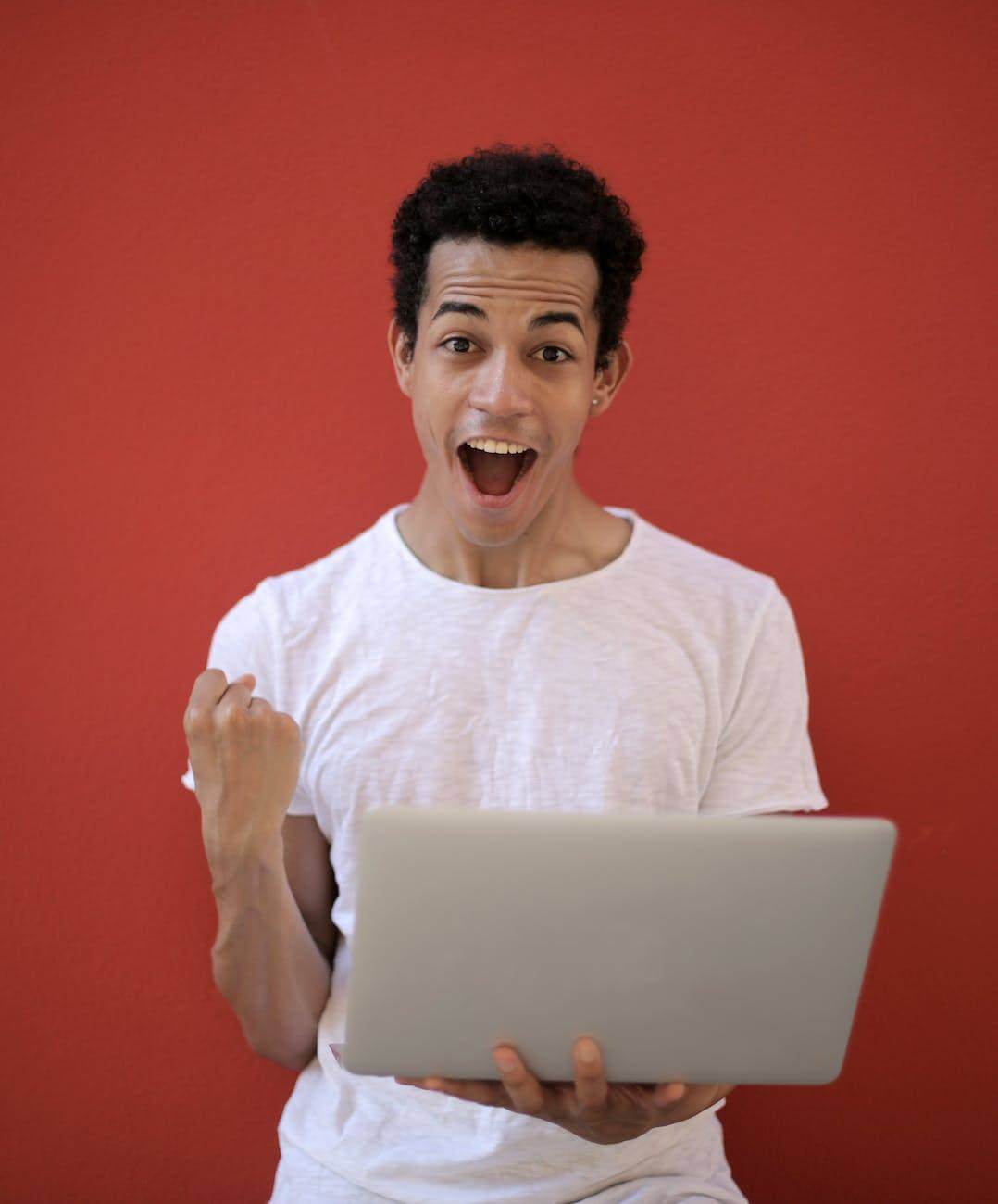 man in white crew neck t shirt holding laptop